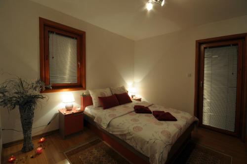 a bedroom with a bed with two lamps on it at IWA CENTAR Apartments & Wellness in Vrnjačka Banja