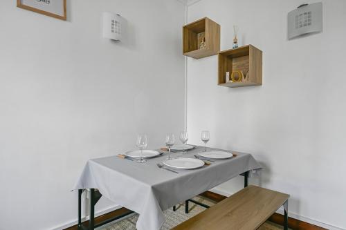 a table with plates and wine glasses on it at Veridian Apartment Métro Le Kremelin-Bicètre in Le Kremlin-Bicêtre
