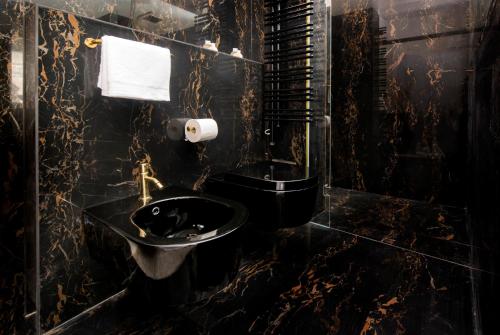 a black bathroom with a toilet and a sink at Spirito Santo Palazzo Storico - Adults Only in Rovinj