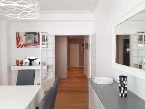 une cuisine blanche avec une table et des chaises dans l'établissement Luxueux 3P en plein cœur de Nice, à Nice