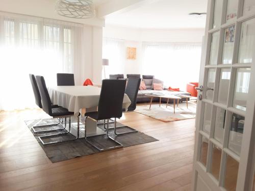 une salle à manger avec une table blanche et des chaises noires dans l'établissement Luxueux 3P en plein cœur de Nice, à Nice