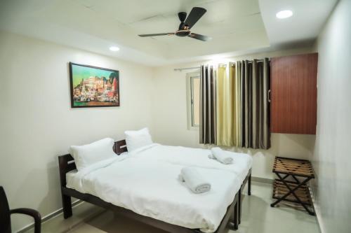 a bedroom with two beds and a ceiling fan at Kashi-Prayagraj Spiritual Yatra in Prayagraj
