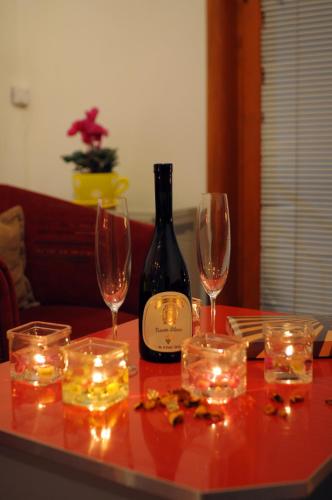 a table with wine glasses and a bottle of wine at IWA CENTAR Apartments & Wellness in Vrnjačka Banja