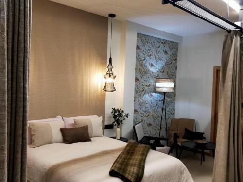 Un dormitorio con una gran cama blanca en una habitación. en Alojamiento Beach Riazor, en A Coruña