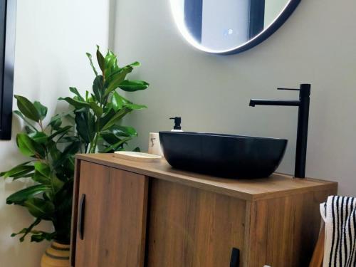 baño con lavabo negro en un armario de madera en Alojamiento Beach Riazor, en A Coruña