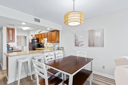 a kitchen and dining room with a wooden table and chairs at Boardwalk 983 in Gulf Shores