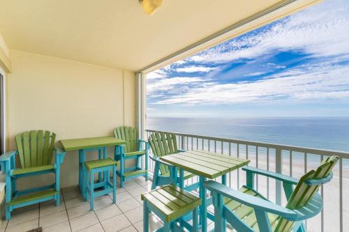a balcony with tables and chairs and a view of the ocean at Boardwalk 983 in Gulf Shores