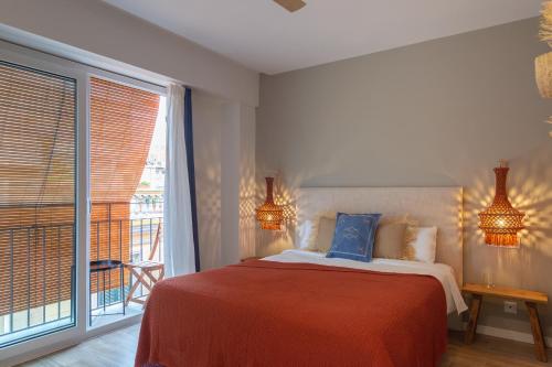 a bedroom with a bed and a large window at Hostal Boutique Es Portalet in Sant Feliu de Guíxols