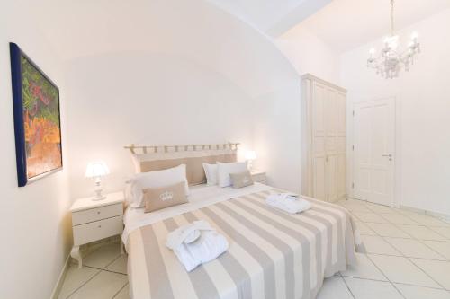 a white bedroom with a large bed with towels on it at Queen Suite - Luxury Rooms in Ischia