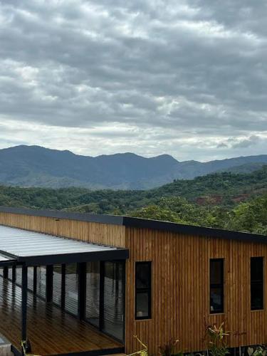 a building with a deck with mountains in the background at Sunhi Vista Eco-Resort in Torio