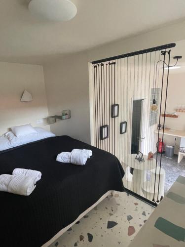 a bedroom with a black bed with two white towels at Boutique Hotel U zvonku in Třeboň
