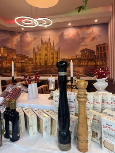 a table with wine bottles on it with a painting at Hotel Les Jardins Carol in Bucharest