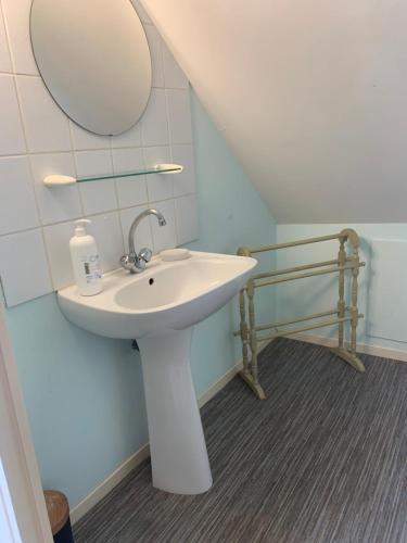 une salle de bain avec un lavabo et un miroir dans l'établissement Two Cottages in Beautiful Brittany 5 Bedrooms Sleeps 10 Pets Welcome Heated Swimming Pool Free Wifi, à Plouguenast Langast