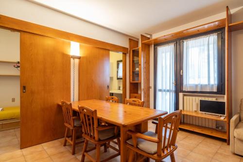 a dining room with a wooden table and chairs at Il Giardino in Centro paese in Barzio