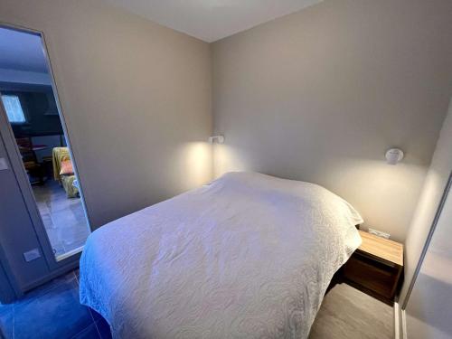 une chambre avec un lit blanc et un miroir dans l'établissement Calme Appartement T2 avec Terrasse à Cavalaire - FR-1-226B-2, à Cavalaire-sur-Mer