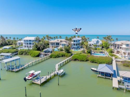 a dock with a boat on the water in front of houses at Captiva Grace home in Captiva