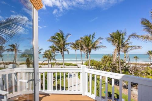 a balcony with a view of the beach and palm trees at Captiva Grace home in Captiva
