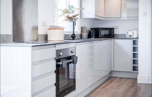 a kitchen with white cabinets and a stove top oven at Angle Adventures - sleeps 8 in Angle