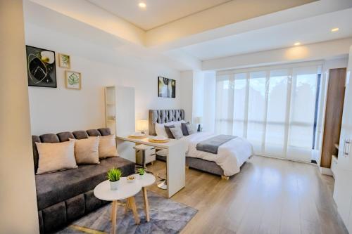 ボゴタにあるCozy Loft in the Heart of the Cityのベッドとソファのあるリビングルーム