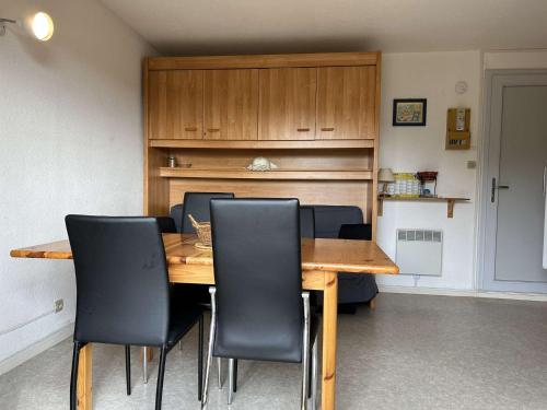 une salle à manger avec une table en bois et des chaises noires dans l'établissement SP430-635 Appt 2 pièces 4 couchages SAINT PIERRE LA MER, à Saint Pierre La Mer