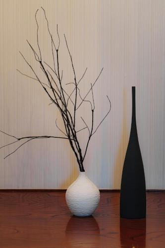 two vases sitting on a table with branches in them at Von Voyage 甲府 in Kofu