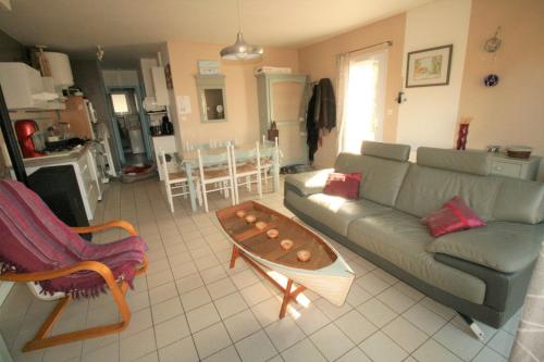 un salon avec un canapé et une table dans l'établissement Vacances en bordure de forêt domaniale, à La Tranche-sur-Mer