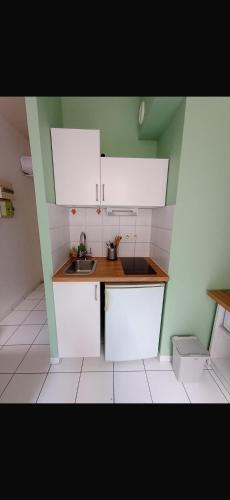 une petite cuisine avec des armoires blanches et un évier dans l'établissement Studio dans le centre ville !, à Bourges