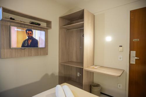 a bathroom with a tv on the wall at Abbeville Hotel Torre I - Torre II in São Luís