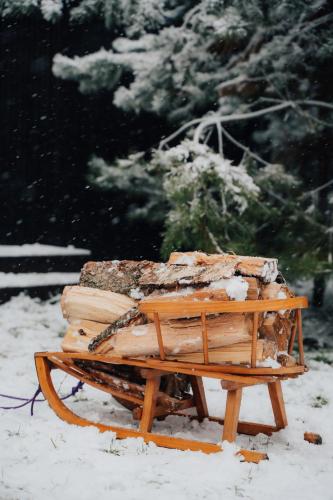 a pile of logs sitting on a sled in the snow at Charszówka in Kobrzyniec Stary