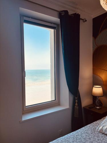 a bedroom window with a view of the beach at Villa Ker Eole Vue Mer in Dinard