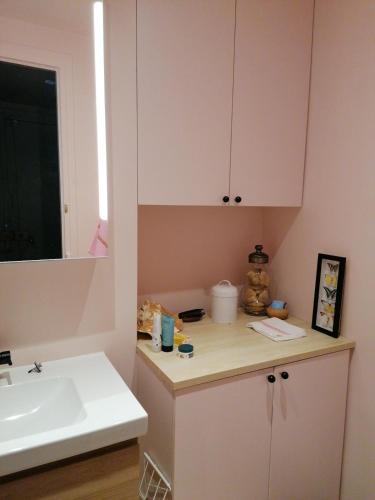La salle de bains est pourvue d'un lavabo et d'un comptoir blanc. dans l'établissement Bel appartement Hausmannien au centre de Paris, à Paris