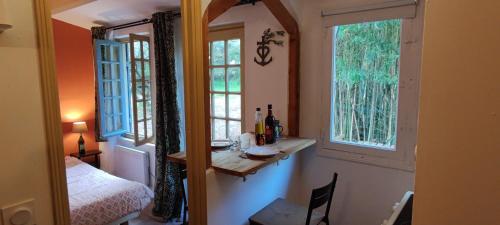 Cette petite chambre dispose d'une table et de deux fenêtres. dans l'établissement Cabanon St Joseph, 2 personnes, à Boulbon