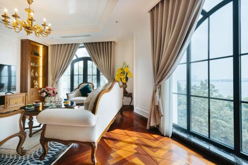 a living room with a chandelier and large windows at Luxe Paradise Suite Hotel Trich Sai in Hanoi