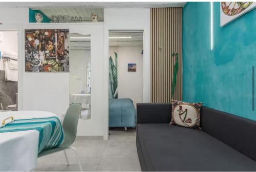 a living room with a couch and a blue wall at Apartment al Vicolo 27 in Palermo