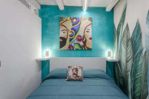a bedroom with blue walls and a bed with a pillow at Apartment al Vicolo 27 in Palermo