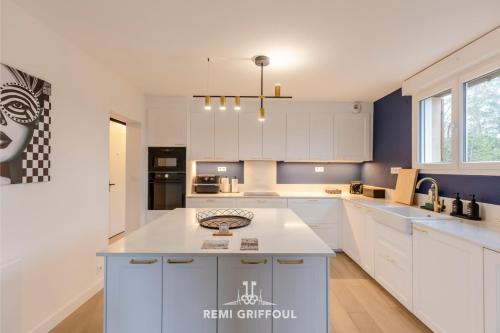 eine Küche mit weißen Schränken und einer Arbeitsplatte in der Unterkunft Villa Canet - Jacuzzi - Fireplace - Sauna EV 10P in Gonneville-sur-Honfleur