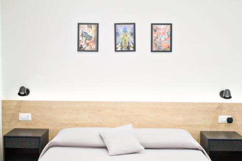 a bedroom with a bed with four pictures on the wall at Napoli Vitale Apartments in Naples