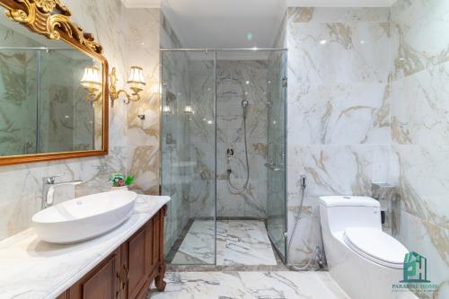 a bathroom with a shower and a toilet and a sink at Luxe Paradise Suite Hotel Trich Sai in Hanoi