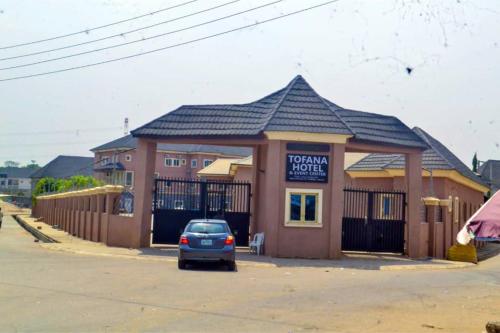 a building with a car parked in front of it at Tofana Hotel and Event Center in Abuja