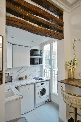 - une cuisine blanche avec lave-linge et sèche-linge dans l'établissement L'appartement du duc de Choiseul - Coeur Opéra, à Paris