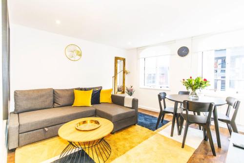 a living room with a couch and a table at Accomodo London Soho - Elegant Apartments near Carnaby Street and Oxford Street in London