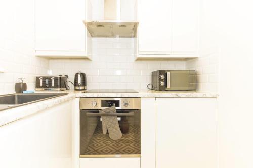 a kitchen with a stove top oven with a towel on it at Accomodo London Soho - Elegant Apartments near Carnaby Street and Oxford Street in London