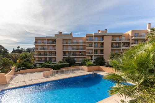 un grand immeuble d'appartements avec une grande piscine dans l'établissement Happyfew appartement les palmiers, à Nice