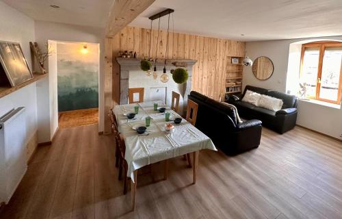 a living room with a table and a couch at Le belvédère des deux lacs in Le Brey et Maison du Bois
