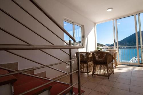 a living room with a table and chairs and windows at Bed and breakfast Jadran in Neum