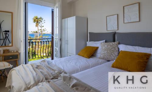 a bedroom with two beds with a view of the ocean at Théa Lassi 2 bedroom apartment, First floor in Argostoli