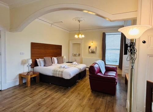una camera d'albergo con letto e sedia di The Claymore Guest House a Pitlochry