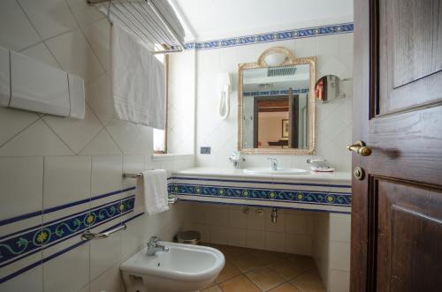 a bathroom with a sink and a toilet and a mirror at Hotel Ristorante le Gole di Ricci in Aielli