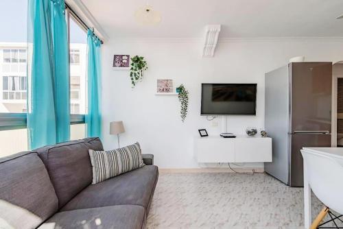 a living room with a couch and a tv at Apartment 5 minutes from the sea in Playa del Ingles