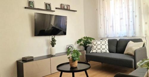 a living room with a couch and a tv on a wall at Mb Homes Beuren in Balzholz